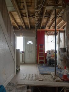 A homeowner carefully restoring original wood trim in an old house interior.