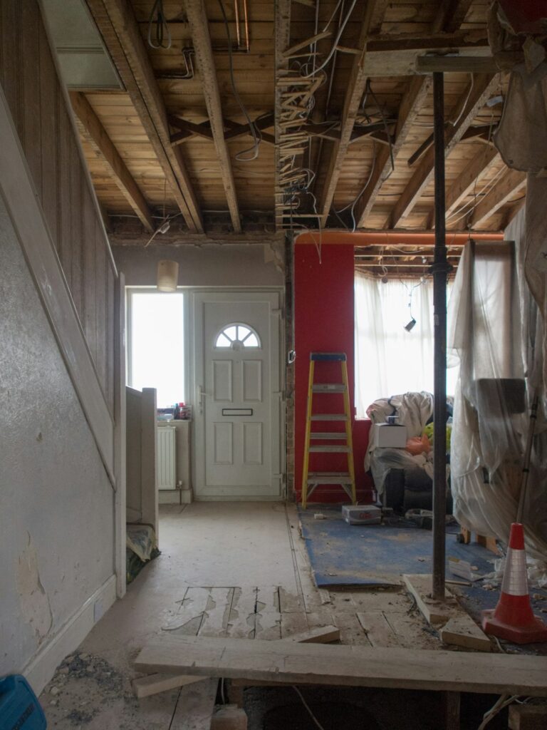 A homeowner carefully restoring original wood trim in an old house interior.
