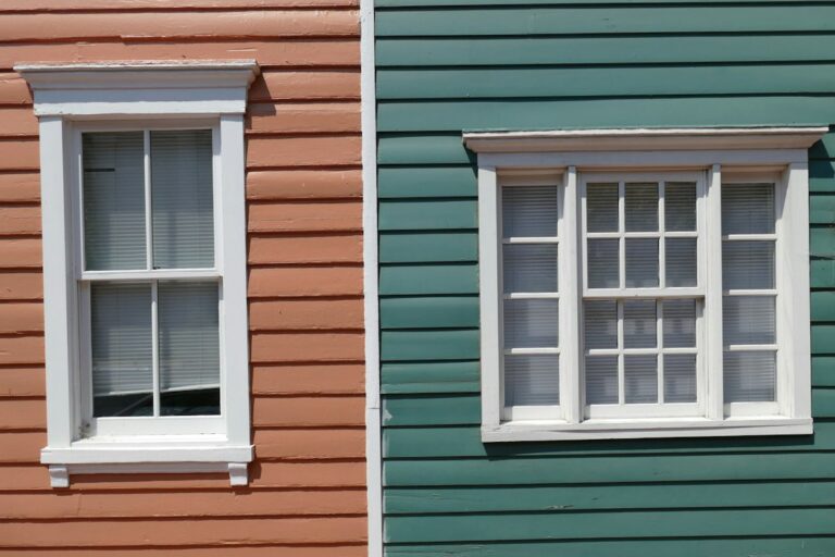 Homeowners repair a historic wood window beside original trim, tools, paint, and restored plaster walls.