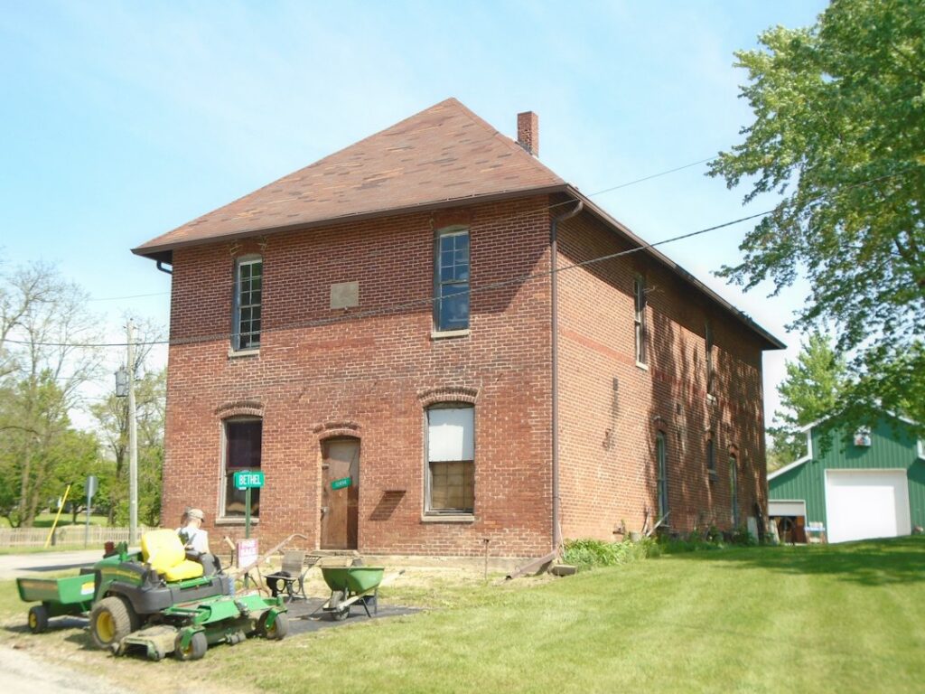 A homeowner and specialist examine original wood trim, plaster, and masonry inside an older house.