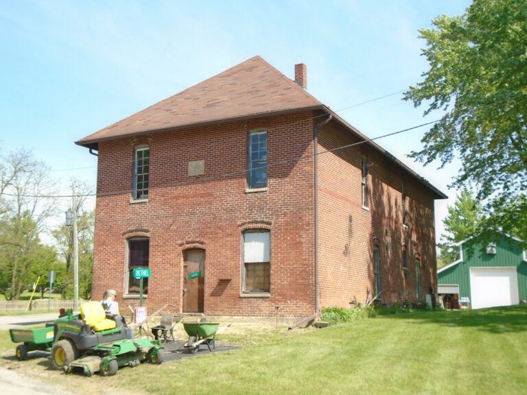 A homeowner and specialist examine original wood trim, plaster, and masonry inside an older house.