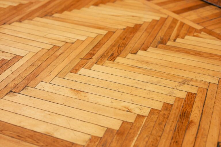 Restored wood floorboards with visible patina in a bright historic home interior.